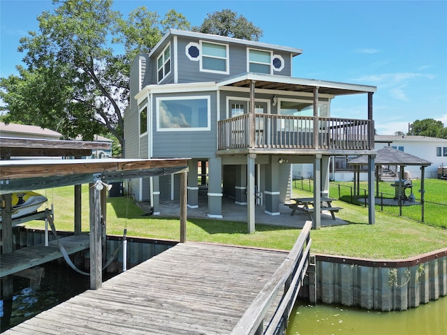 rear view of house featuring a patio, a lawn, and a water view