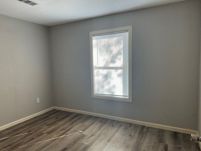 unfurnished room with plenty of natural light and hardwood / wood-style floors