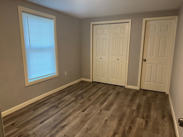 unfurnished bedroom with dark wood-type flooring