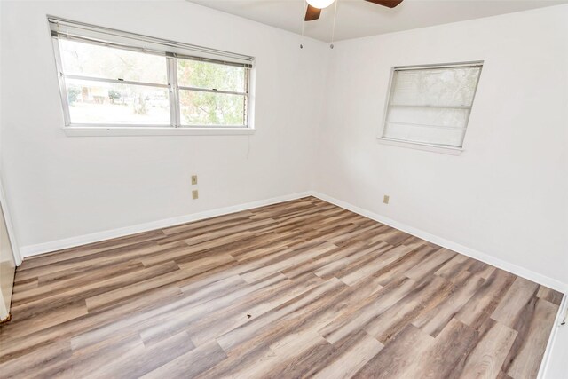 empty room with ceiling fan and hardwood / wood-style flooring