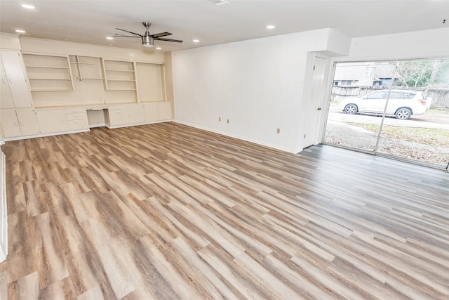 unfurnished living room featuring light wood-type flooring and ceiling fan