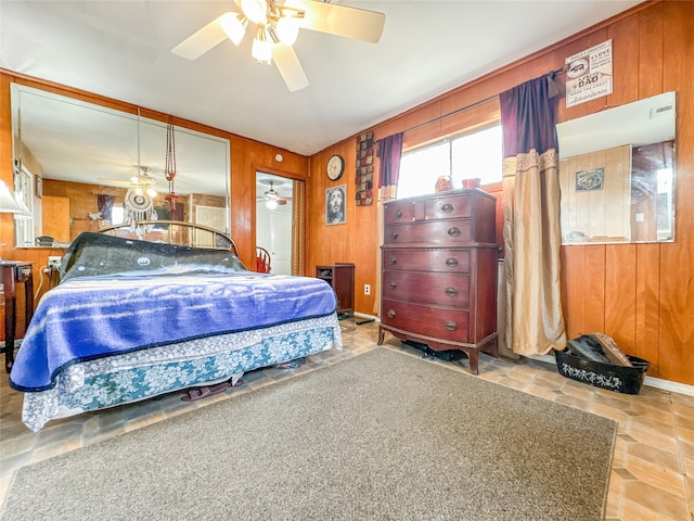 tiled bedroom with ceiling fan and wood walls