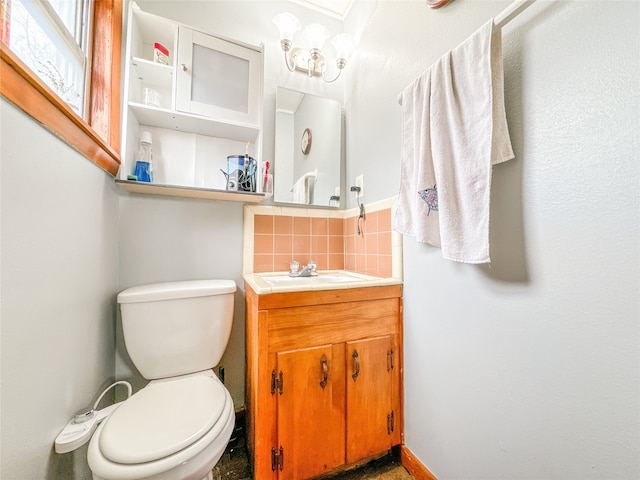 bathroom featuring tasteful backsplash, vanity, and toilet