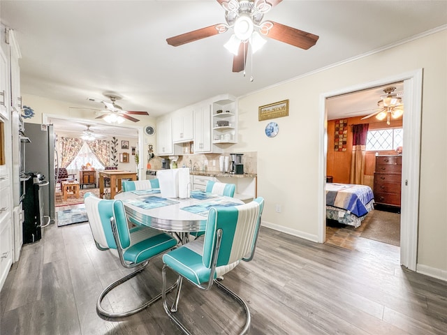 dining space featuring ceiling fan, wood-type flooring, and sink