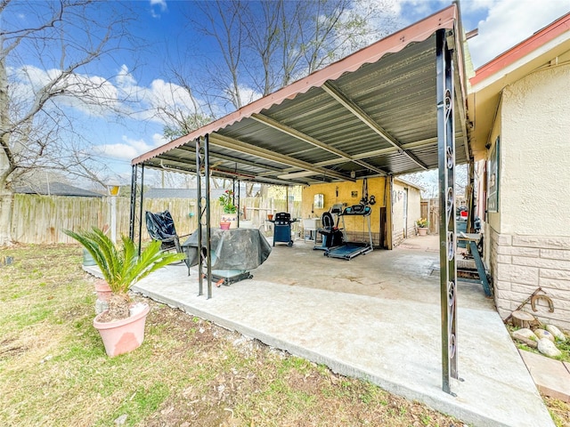 view of parking with a carport and fence