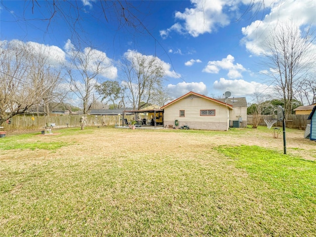 view of yard featuring a patio area, a fenced backyard, and central AC unit