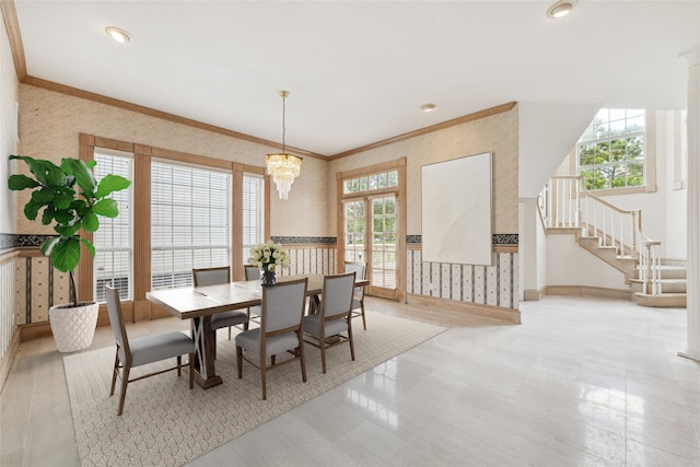 dining area with crown molding and an inviting chandelier