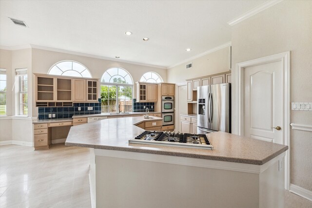 kitchen featuring decorative backsplash, appliances with stainless steel finishes, light brown cabinets, and a spacious island