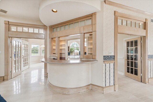 interior space featuring a healthy amount of sunlight, light tile patterned floors, and french doors