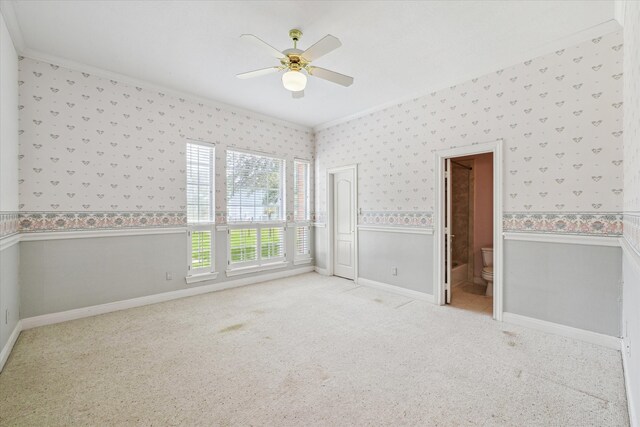 unfurnished bedroom with carpet floors, ensuite bathroom, crown molding, and ceiling fan