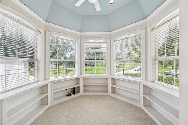 unfurnished sunroom featuring ceiling fan, plenty of natural light, and lofted ceiling