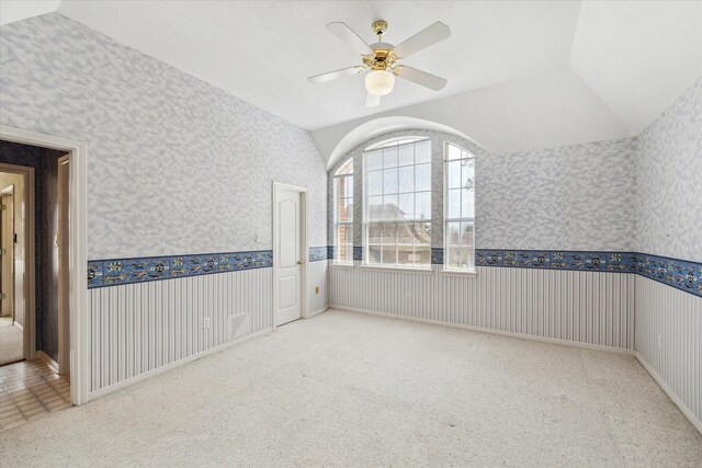 carpeted empty room featuring ceiling fan and lofted ceiling