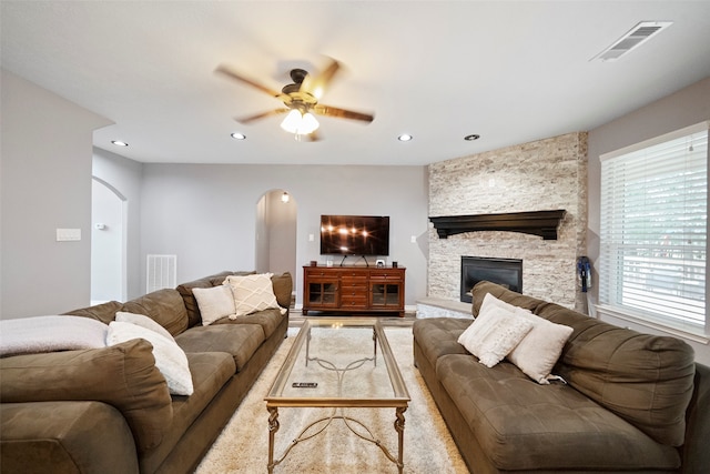 living room featuring ceiling fan and a fireplace