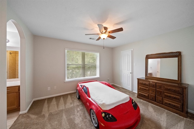 bedroom featuring ceiling fan, connected bathroom, and carpet flooring