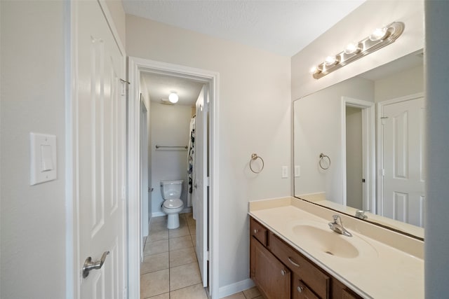 bathroom with tile patterned floors, a textured ceiling, vanity, and toilet