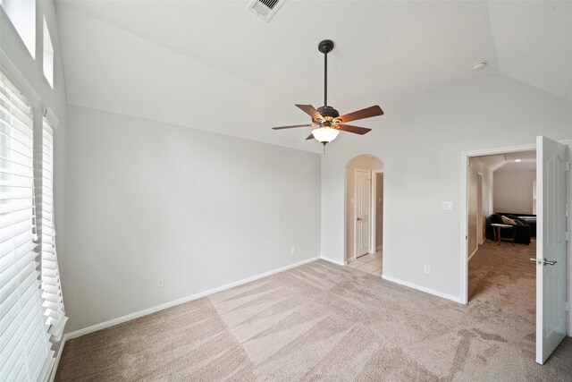 unfurnished bedroom with light colored carpet, vaulted ceiling, and ceiling fan