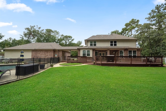 back of property featuring a pool side deck and a lawn