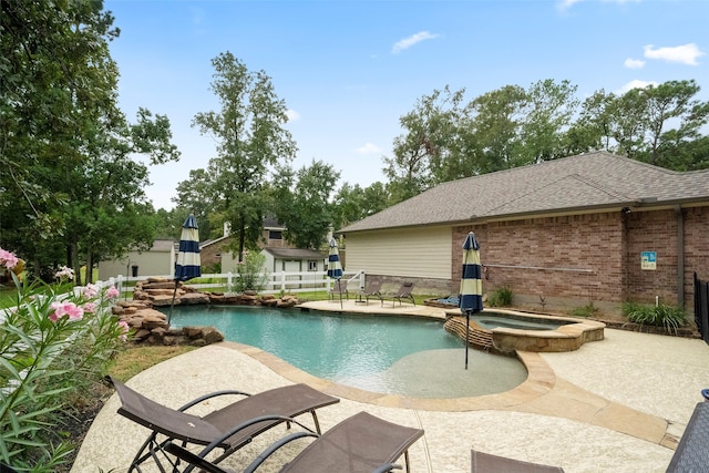 view of swimming pool featuring a patio, an in ground hot tub, and an outdoor structure