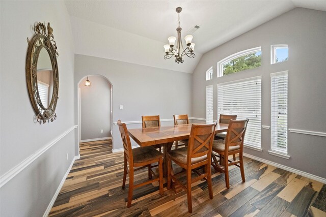 dining room featuring dark hardwood / wood-style floors, an inviting chandelier, and lofted ceiling