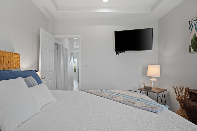 bedroom featuring hardwood / wood-style floors and a raised ceiling