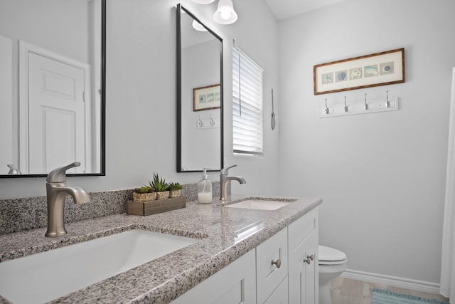 bathroom with tile patterned floors, double vanity, and toilet