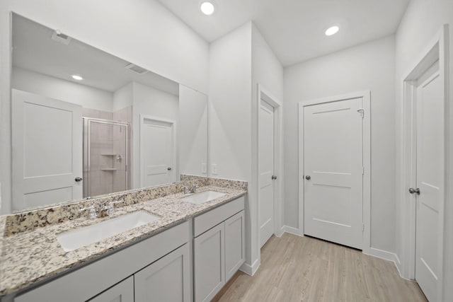 bathroom featuring vanity, wood-type flooring, and an enclosed shower