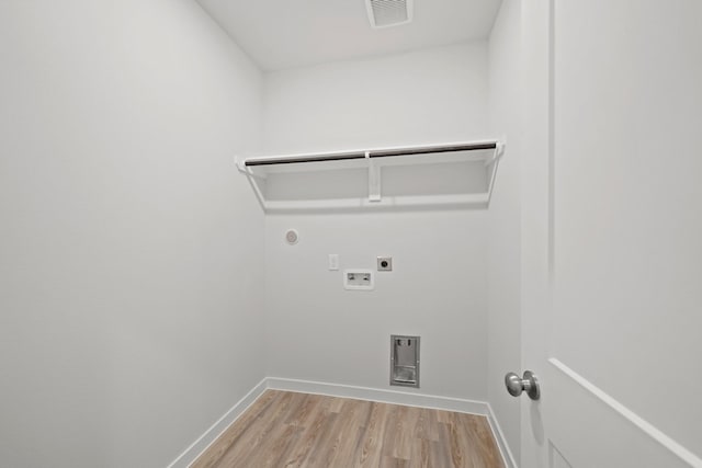 washroom with gas dryer hookup, hookup for a washing machine, light hardwood / wood-style flooring, and hookup for an electric dryer