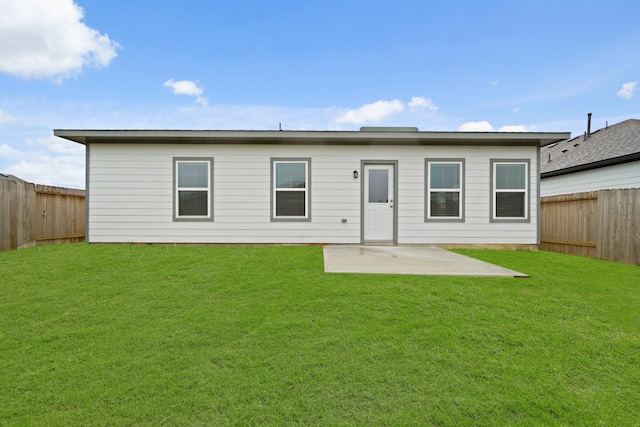 back of property with a lawn and a patio area