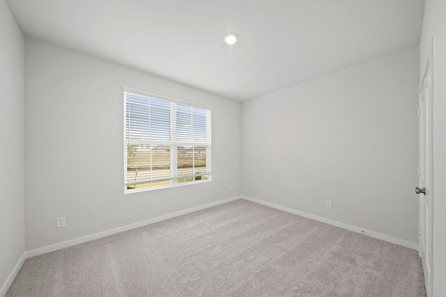 spare room featuring light colored carpet