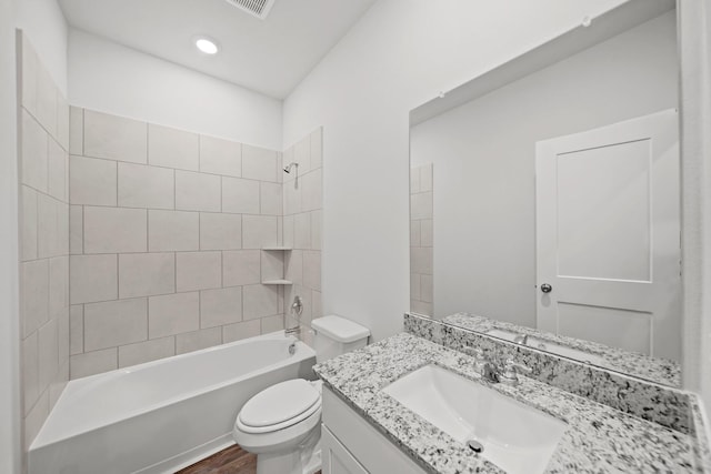 full bathroom featuring toilet, hardwood / wood-style floors, vanity, and tiled shower / bath