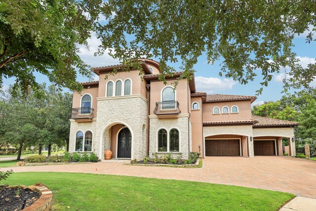 mediterranean / spanish-style house with a balcony and a front yard