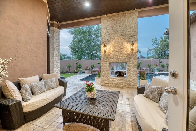 view of patio featuring a fenced in pool and an outdoor living space with a fireplace