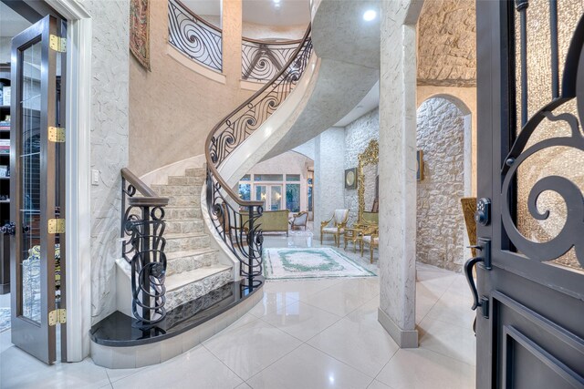 tiled foyer entrance featuring a towering ceiling