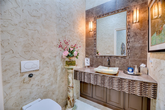 bathroom featuring tile walls, toilet, tile patterned floors, vanity, and backsplash