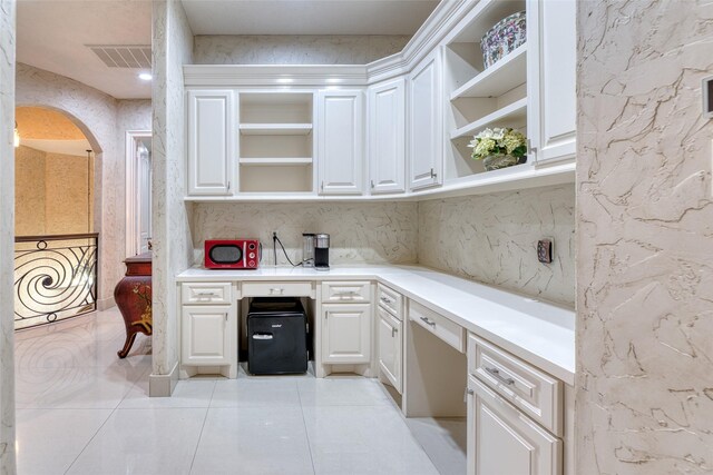 kitchen featuring light tile patterned flooring and white cabinetry