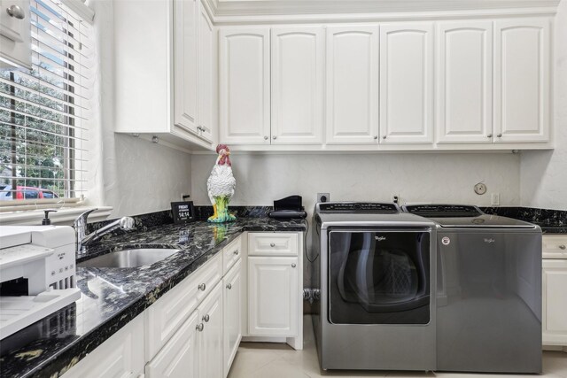 laundry area with sink, light tile patterned floors, cabinets, and separate washer and dryer