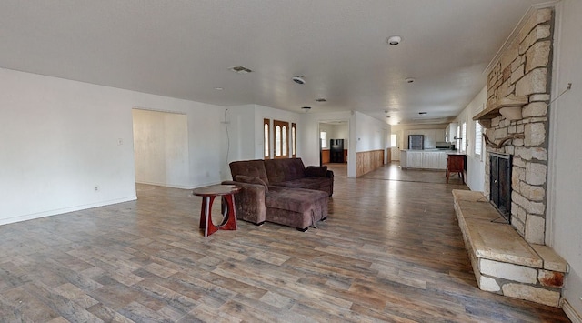 living room featuring a stone fireplace and hardwood / wood-style flooring