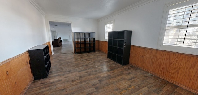 unfurnished room featuring wood walls, ornamental molding, and dark wood-type flooring