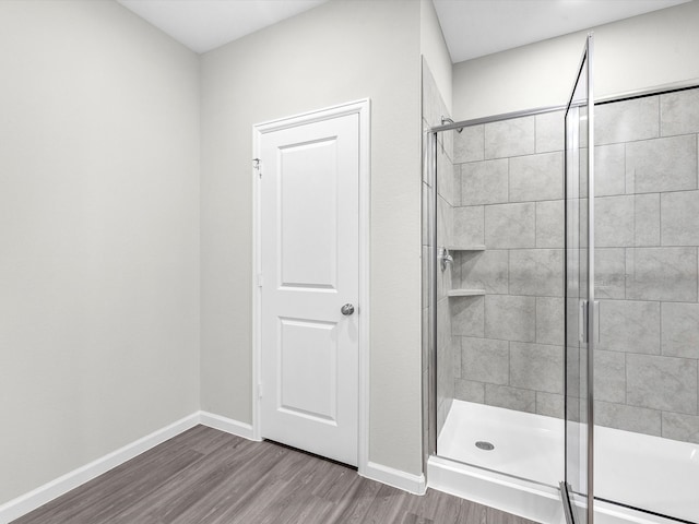 bathroom featuring hardwood / wood-style floors and a shower with shower door