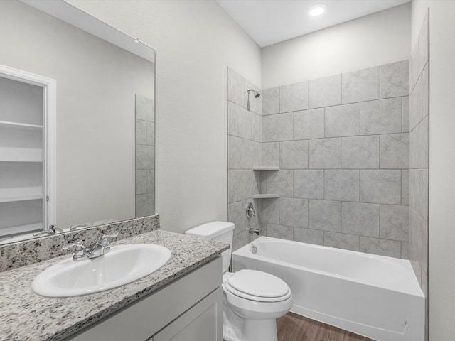 full bathroom with vanity, toilet, hardwood / wood-style floors, and tiled shower / bath