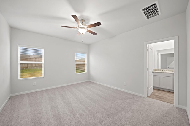 carpeted empty room with a wealth of natural light and ceiling fan