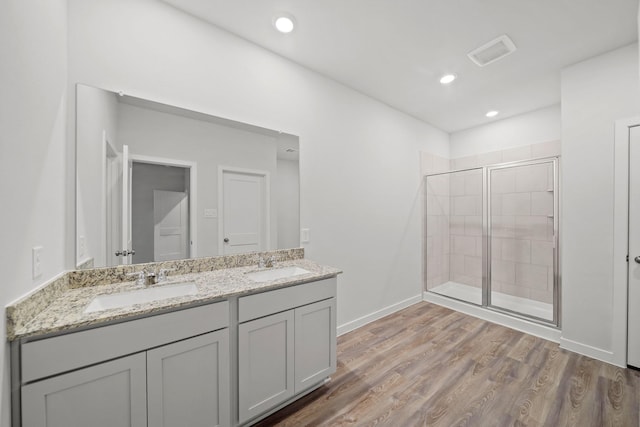 bathroom featuring vanity, wood-type flooring, and walk in shower