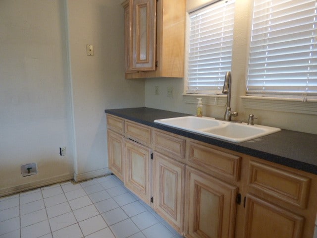 kitchen featuring light tile patterned flooring, light brown cabinets, and sink