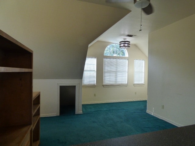 additional living space with ceiling fan, vaulted ceiling, and carpet