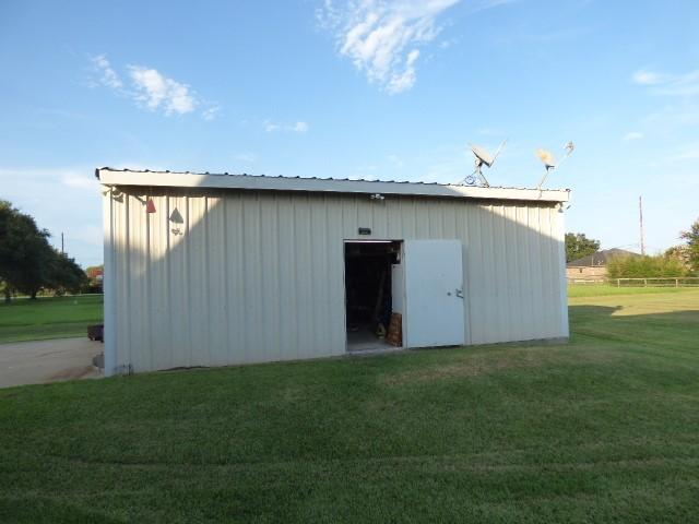 view of outdoor structure featuring a lawn