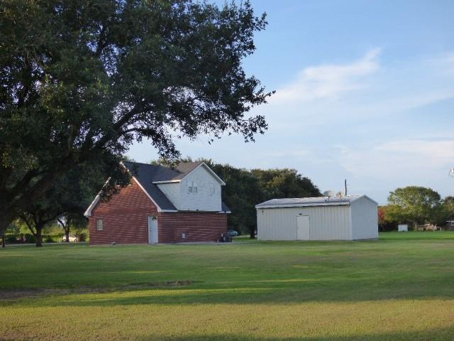 view of property exterior featuring a lawn and an outbuilding