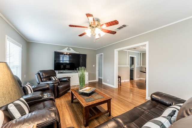 living room featuring ceiling fan, crown molding, and wood-type flooring