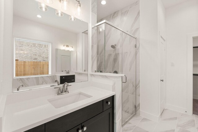 bathroom with baseboards, a sink, marble finish floor, a shower stall, and two vanities