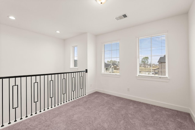 unfurnished room with carpet, visible vents, baseboards, and recessed lighting