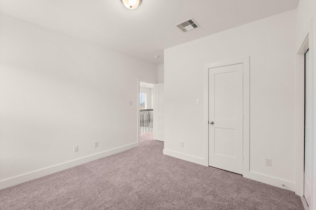 unfurnished bedroom featuring light carpet, visible vents, and baseboards